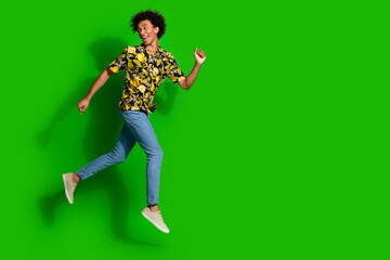 Wall Mural - Photo of funky nice positive man wear trendy summer print clothes run away empty space isolated on green color background