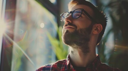 Poster - An individual looks thoughtfully out a sunlit window, capturing a moment of deep reflection and thoughtfulness, accompanied by the warm hues of morning or evening sunlight.