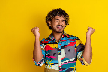 Poster - Photo portrait of pretty young guy raise fists confident winning wear trendy colorful outfit isolated on yellow color background