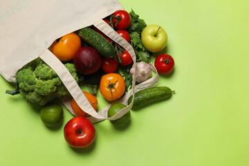 Poster - Delivery of vegetarian products. Bag with different vegetables and fruits on green background, top view. Space for text