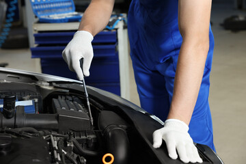 Wall Mural - Auto mechanic fixing car at automobile repair shop, closeup