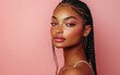 © Surachetsh - Portrait of a young African American woman with braided hair, wearing a pink outfit and full makeup, against a pink studio backdrop.