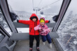 © Studio Peace - Happy children ride a ski lift in the mountains in winter.