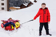 © Studio Peace - Happy children, brother and sister, snow tubing in the mountains in winter.