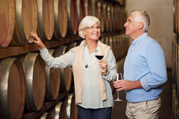 Poster - Wine cellar, barrel and senior couple with glass, talking and celebration with alcohol, industry and retirement. Happiness, woman and man with production, manufacturing and smile with relationship