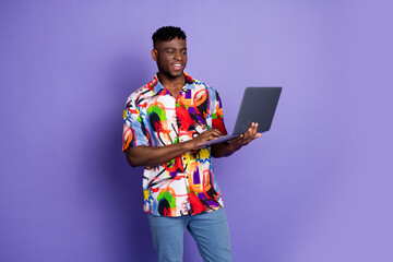 Wall Mural - Photo portrait of handsome young guy hold netbook ecommerce dressed stylish colorful garment isolated on purple color background