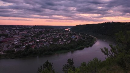 Wall Mural - Ukraine, the meander of the Dniester around the city of Zalishchyky at sunrise and sunsetbridge, houses and road in the Chernivtsi region, fast-motion video of the morning, time lapse.