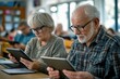 © kitipol - Elderly couple in a tech class, both focused on their tablets as they learn to navigate digital tools