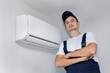 © Studio Peace - Professional technician who installs and maintains a modern indoor air conditioner.
