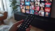 © Nathaphat - Entertainment Choice - Person Selecting Movie on Smart TV with Remote Control