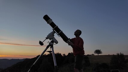 Wall Mural - Amateur astronomer looking at the evening skies, observing planets, stars, Moon and other celestial objects with a telescope in sunset time.
