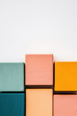 Poster - Colorful wooden blocks arranged against a clean white background, creating a minimalist geometric pattern, perfect for design and creative projects.