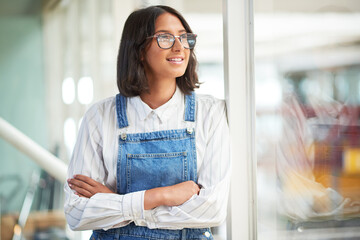 Woman, startup and reflection by window in office for inspiration, ideas and smile for solution. Person, happy and thinking by glass at job with arms crossed, decision and vision at creative agency