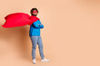 © deagreez - Photo of nice funny cheerful strong man wear trendy costume red mask empty space isolated on beige color background