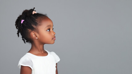 Wall Mural - Side view of African little girl wearing white dress isolated on gray