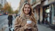 © Nataliya - Cheerful woman in the street drinking morning coffee in sunshine light