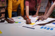 © amnaj - Team of marketing professionals are collaborating on a project, analyzing charts and graphs, and brainstorming ideas