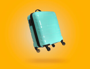 Wall Mural - Turquoise suitcase in air on orange background