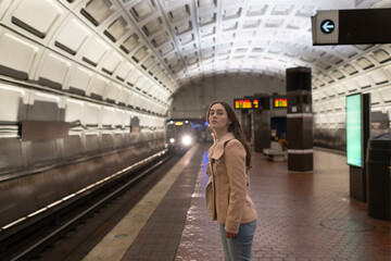 Young woman in metro with a train approaching