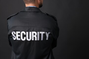 Wall Mural - Security guard in uniform on black background, closeup