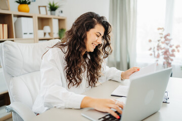 Wall Mural - Young caucasian business woman working in office on laptop