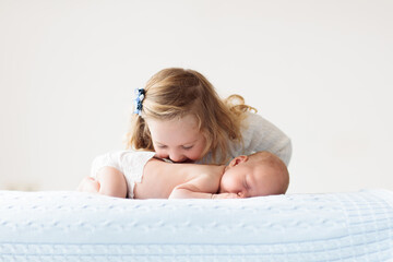 Wall Mural - Child watching newborn baby in bassinet.