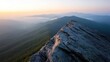 ©  Jovaduplex - A breathtaking view from the top of a rocky mountain summit during sunrise, with the interplay of light and shadow adding depth to the green landscapes below.