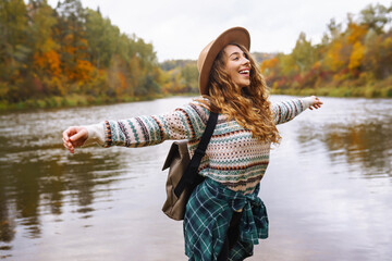 Woman explores new, magical places around the world, surrounded by nature. Female hiker crossing the forest creek. The concept of hiking, travel, vacation.