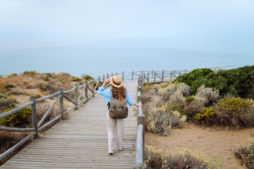 Young female tourist enjoys the view of nature landscapes. Lifestyle, vacation, travel, nature, active life.