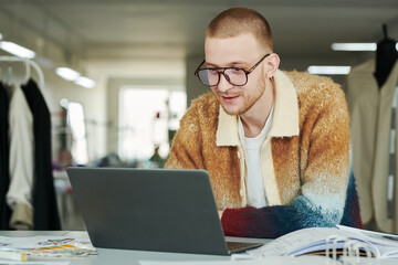 Aufkleber - Young modern fashion designer and owner of atelier looking through online seasonal collections and new trends and tendencies