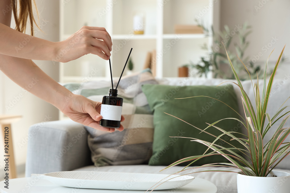 Woman holding aroma diffuser at home