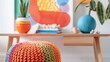 © Justlight - A playful and whimsical desk setup with a rainbowhued knitted pouf and a colorful abstract art piece.