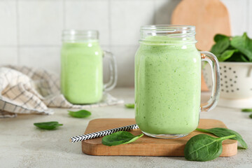 Wall Mural - Mason jars of fresh spinach smoothie on white table