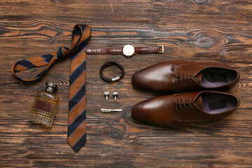 Male shoes with perfume bottle and accessories on wooden background