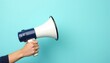 © umut hasanoglu - Person holding a blue and white megaphone against a solid light blue background.