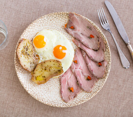 Wall Mural - Appetizing fried eggs with bacon and potatoes served on platter