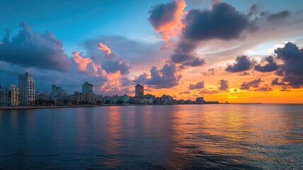 Wall Mural - Vibrant sunset over calm sea and city skyline