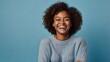 © big bro - Photo of delighted cheerful Afro American woman with crisp hair, points away, shows blank space, happy to advertise item on sale, wears orange jumper