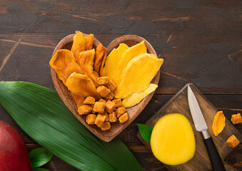 Wall Mural - Heart shape wooden plate with dried mango slices and balls.