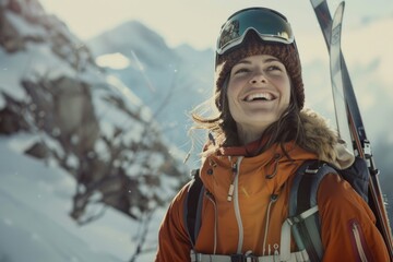 A happy woman standing outside wearing an orange jacket, holding skis, ready for her next adventure