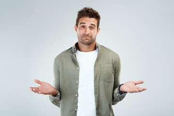 Aufkleber - Man, portrait and confused by doubt, option or decision in gray background with hand gesture in studio. Male person, choice and thinking as frustrated consumer, questioning and contemplating for idea