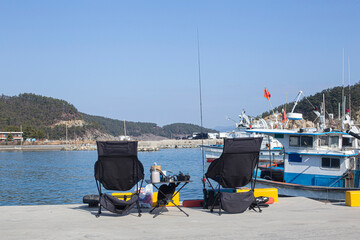 Two fishing rods and chair on the beach near the sea water