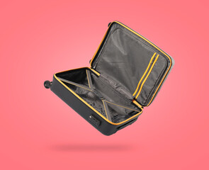 Poster - Open empty suitcase in air on coral background