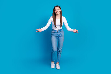 Canvas Print - Full body photo of attractive teen woman stretch hands welcome dressed stylish white clothes isolated on blue color background