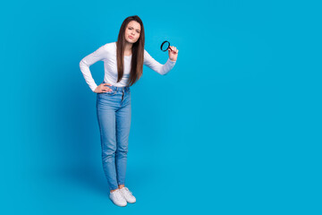 Sticker - Full body photo of attractive teen woman skeptical look magnifier loupe dressed stylish white clothes isolated on blue color background