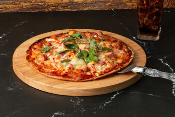 Delicious and appetizing slice of pizza served on a wooden cutting board topped with various ingredients such as cheese, pepperoni, and fresh herbs.