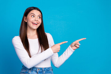 Wall Mural - Photo portrait of lovely teen lady point look empty space dressed stylish white garment isolated on blue color background