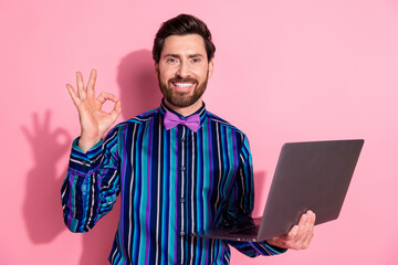 Poster - Photo of cheerful groomed elegant man wear trendy striped clothes recommend gadget okey sign isolated on pink color background