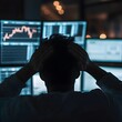 © Nut S. - A stressed-out investor clutching their head in despair as stock charts and financial news blur in the background.