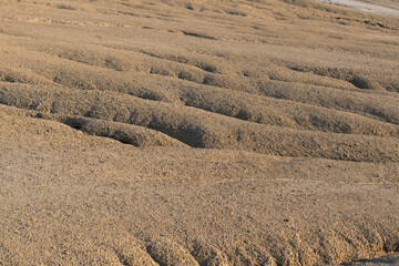 Arid landscape with mud rivers formations in Romania. This is a unique geological phenomenon where the earth gas reaches the surface through hills making small mud volcanoes and a remarkable landscape